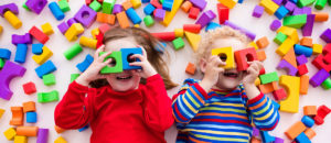 Children playing with colorful blocks building a block tower